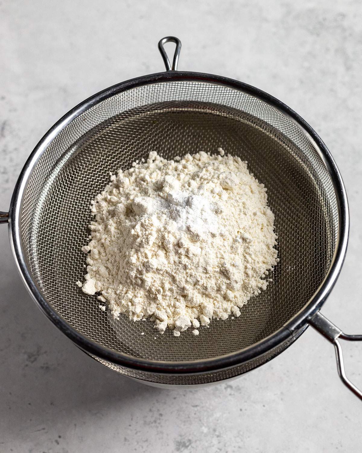 dry ingredients in a sieve above a bowl