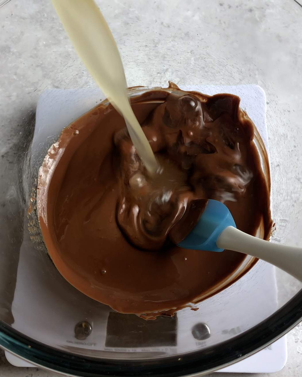 mixing chocolate and wet ingredients in a glass bowl