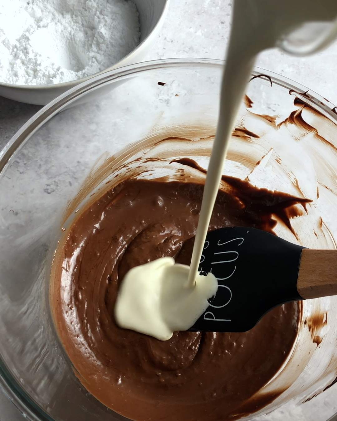 pouring cream into melted chocoolate