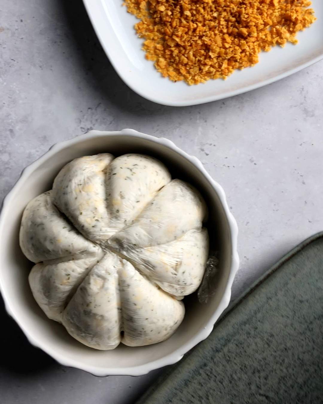 the unwrapped pumpkin shaped cheese ball in a white bowl