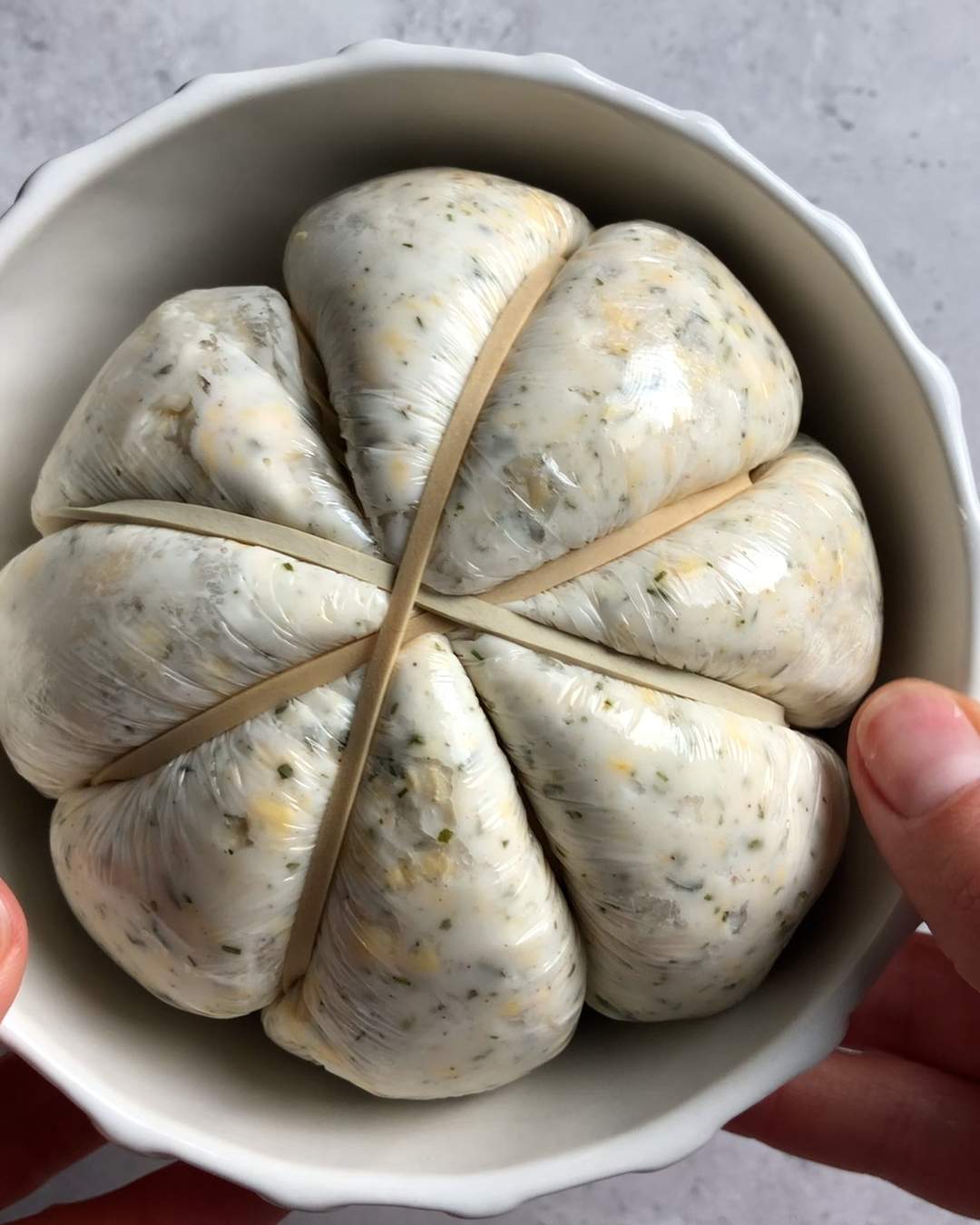 the wrapped and shaped pumpkin cheese call in a white bowl