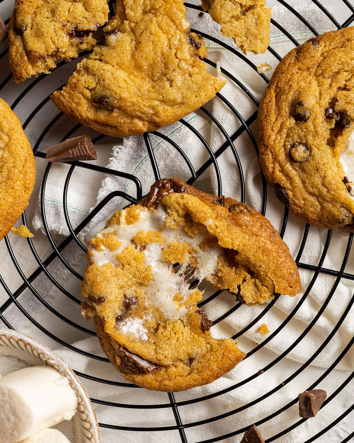 vegan smores cookie on a cooling rack pulled apart to show the gooey vegan marshmallow