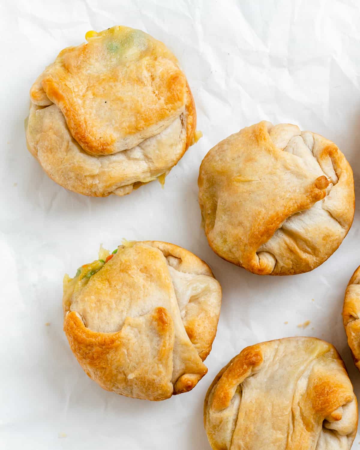 5 vegan mini pot pies on white parchment paper after baking