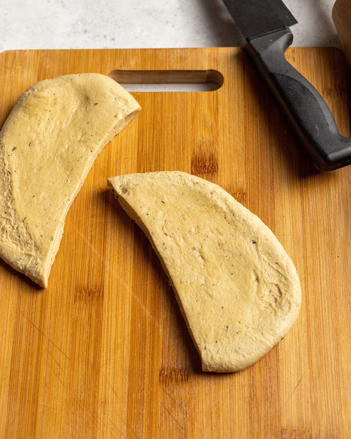 flat pieces of seitan cut into portion sizes on a cutting board