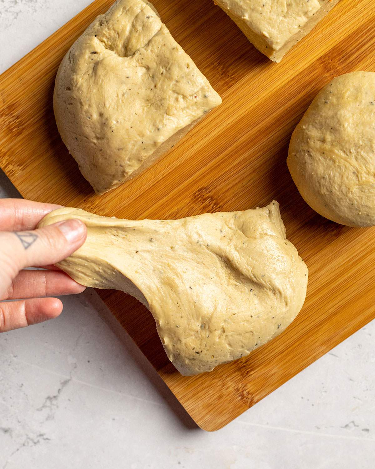 pulling and shaping individual seitan dough pieces for vegan schnitzel by hand