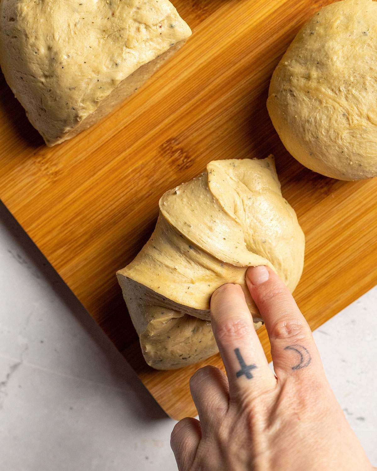 pulling and shaping individual seitan dough pieces for vegan schnitzel by hand