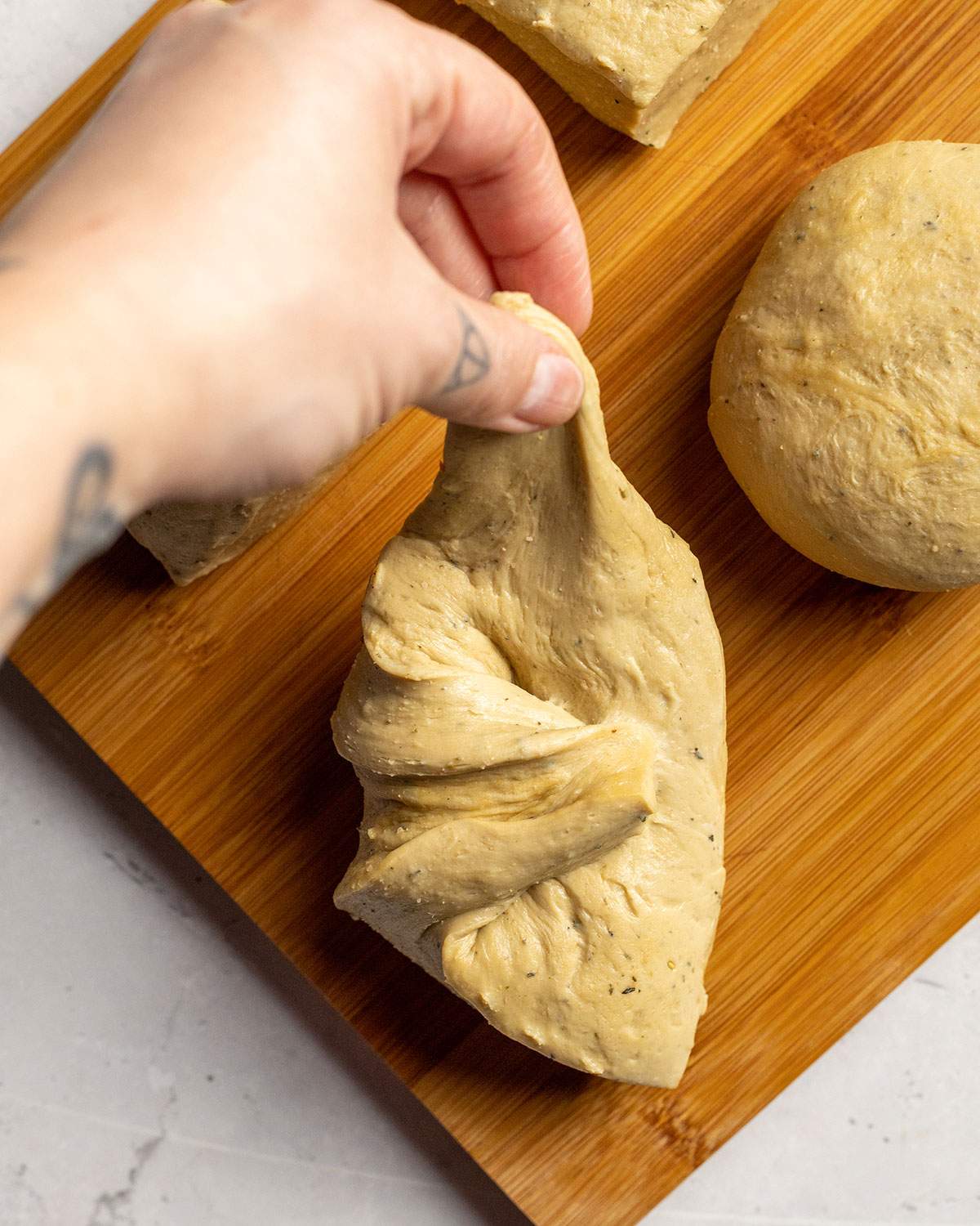 pulling and shaping individual seitan dough pieces for vegan schnitzel by hand
