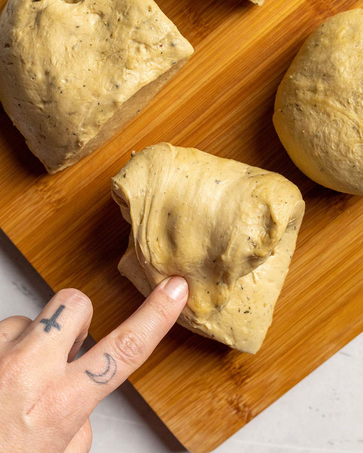 pulling and shaping individual seitan dough pieces for vegan schnitzel by hand