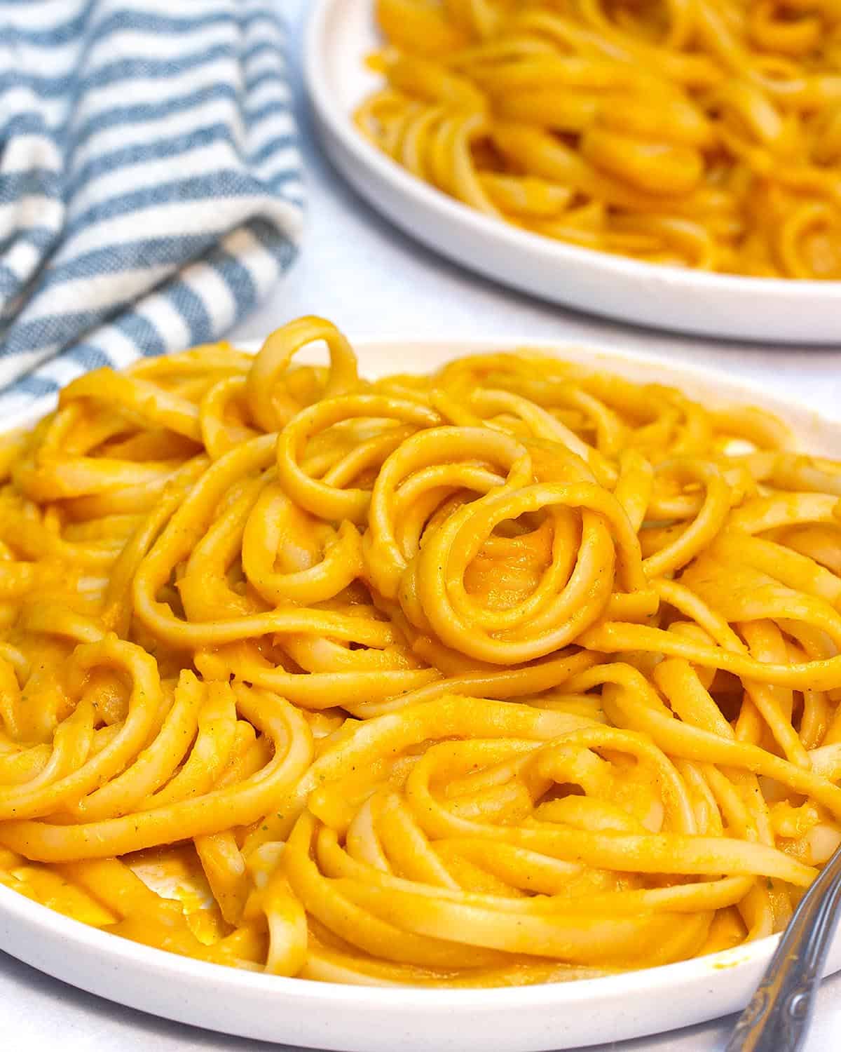 creamy carrot pasta on a white plate