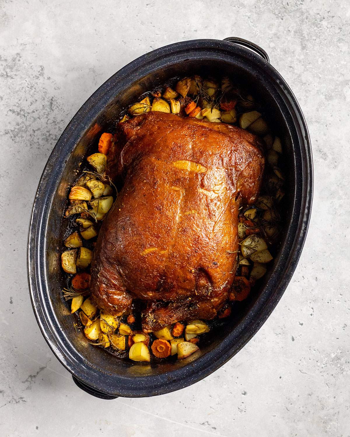 roasted vegan turkey in an oven dish with vegetables