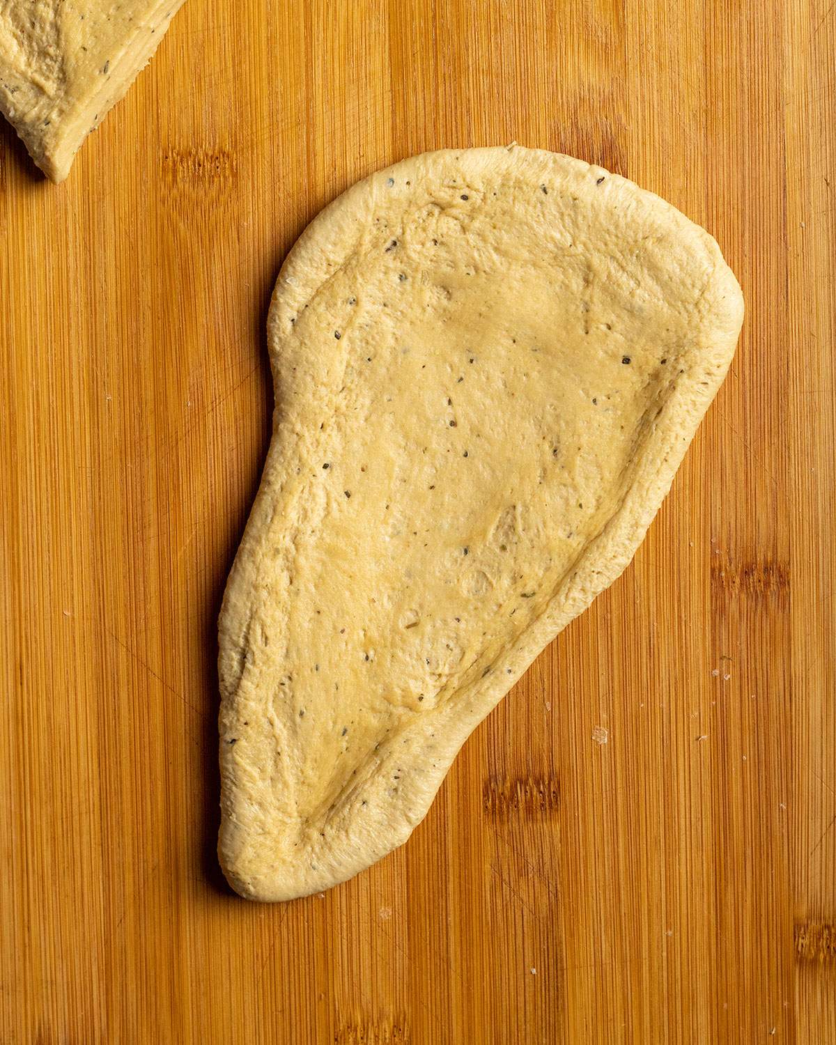 a piece of uncooked seitan shaped like a schnitzel on a cutting board