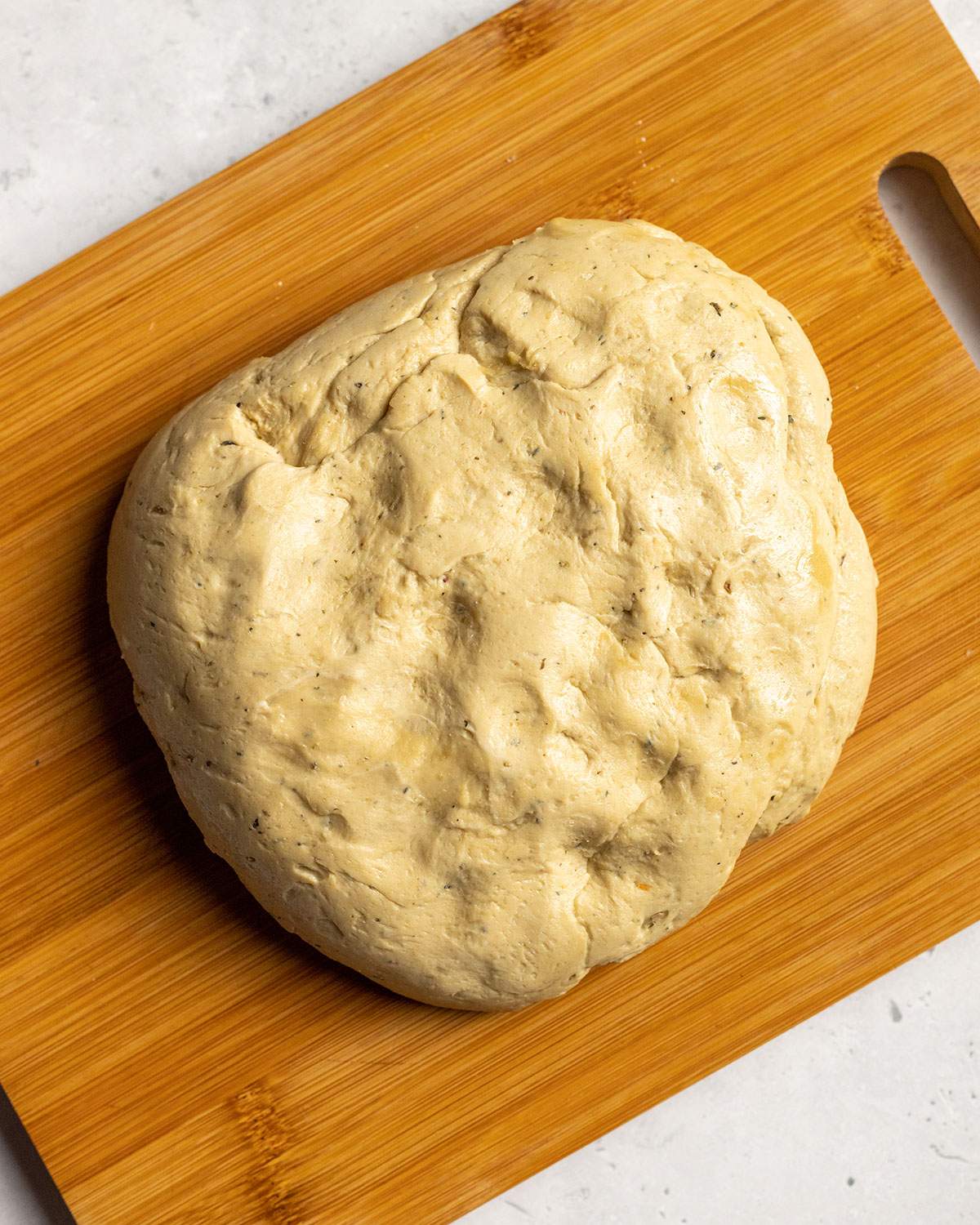 square flattened seitan dough on a cutting board for vegan schnitzel