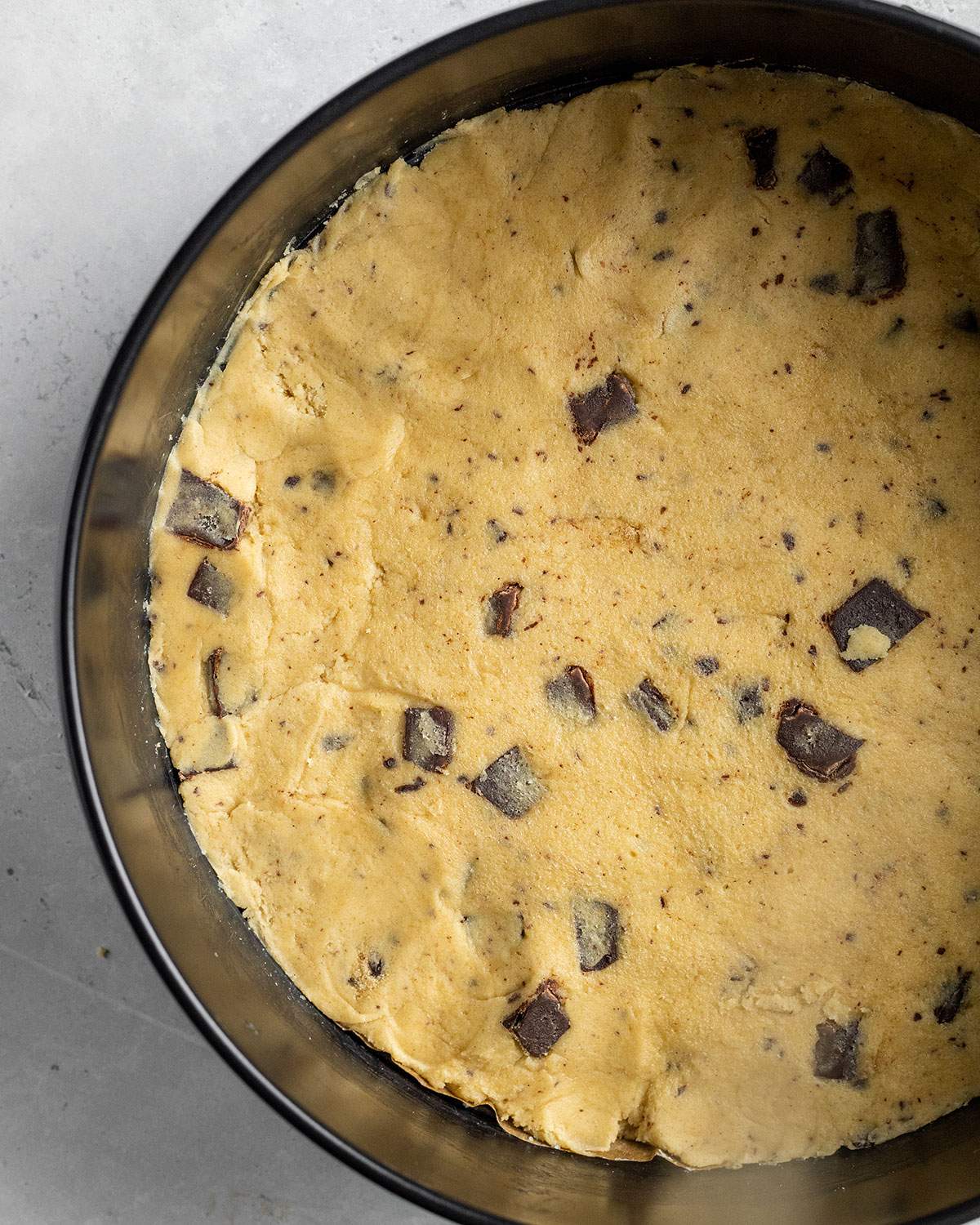 vegan chocolate chip cookie dough in a round springform pan