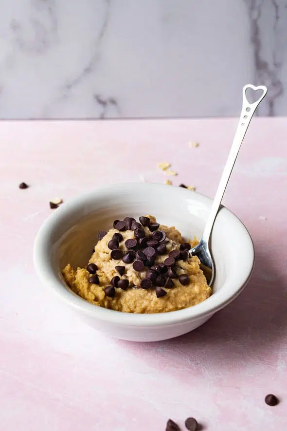 vegan chocolate chip cookie dough in a white bowl with a spoon on the side