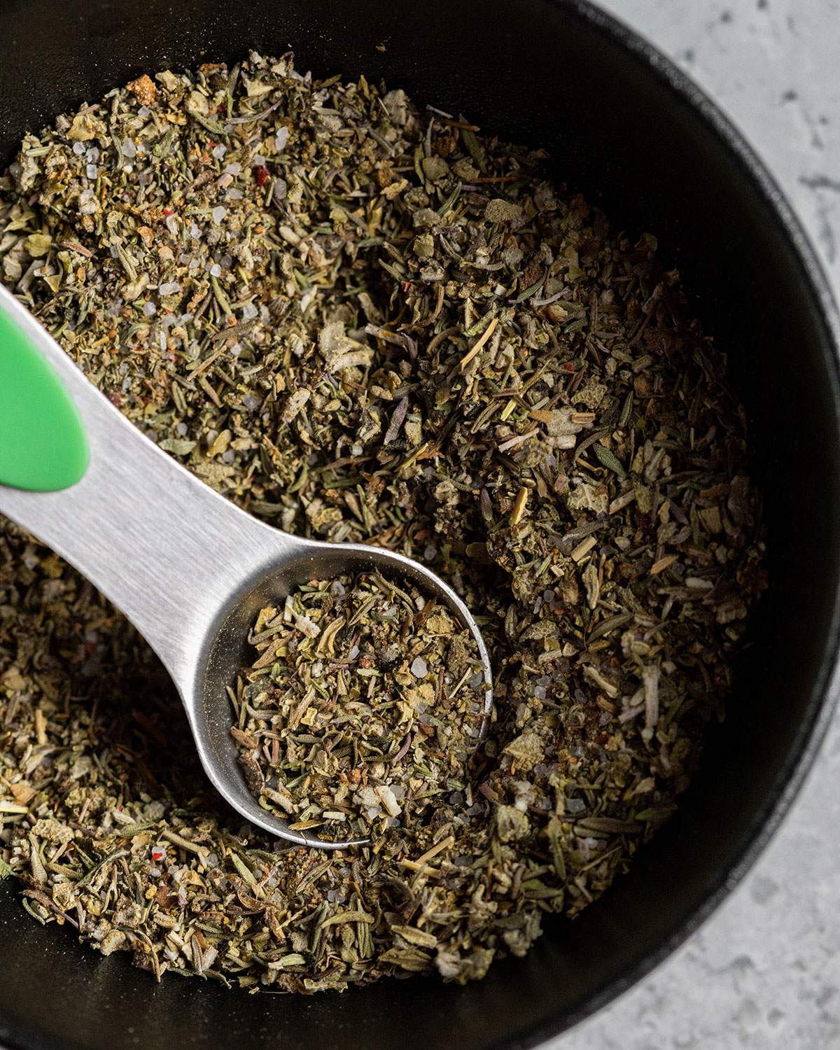 vegan poultry seasoning in a small bowl with a measuring spoon