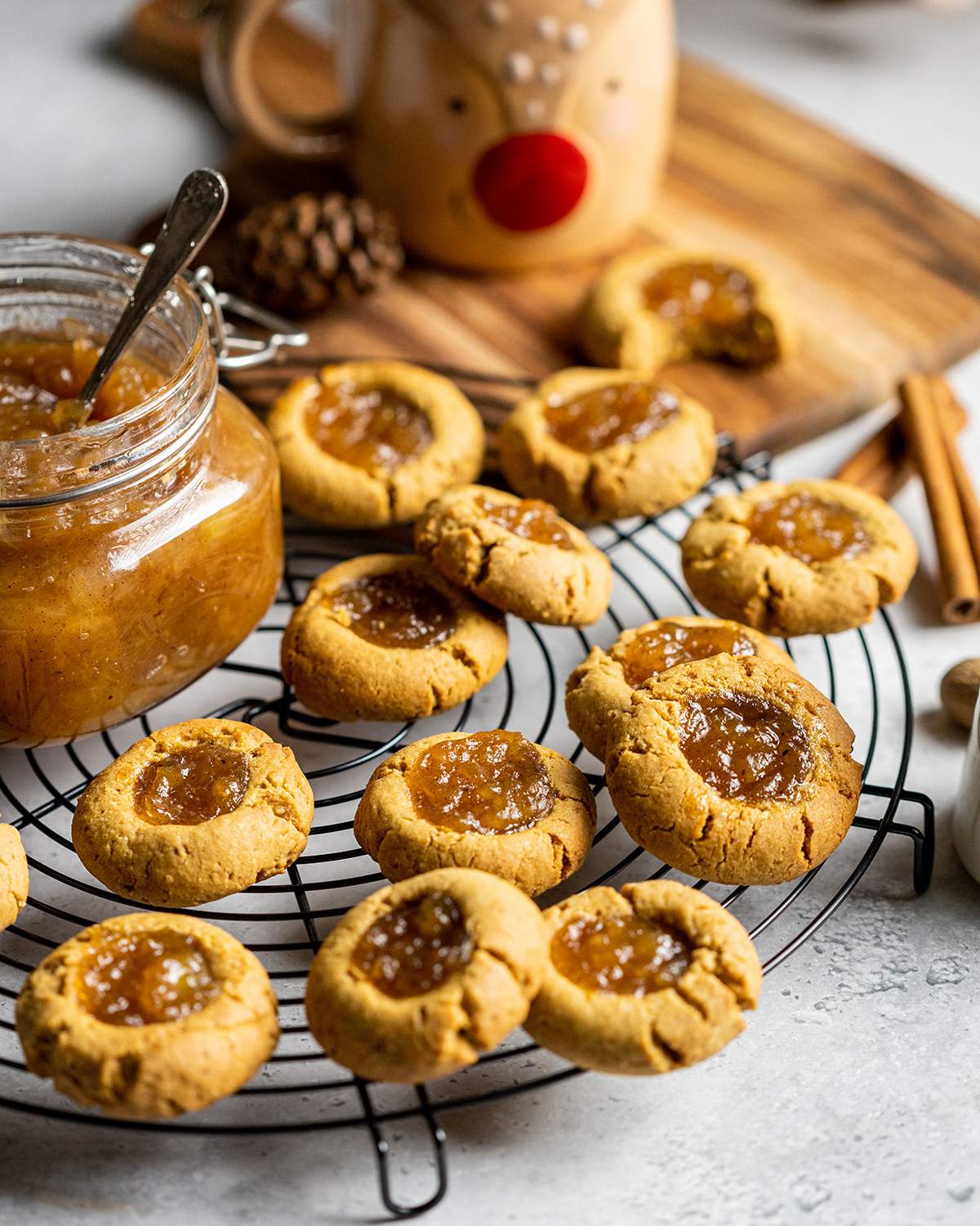 vegan thumbprint cookies with apple pie jam on a cooling rack