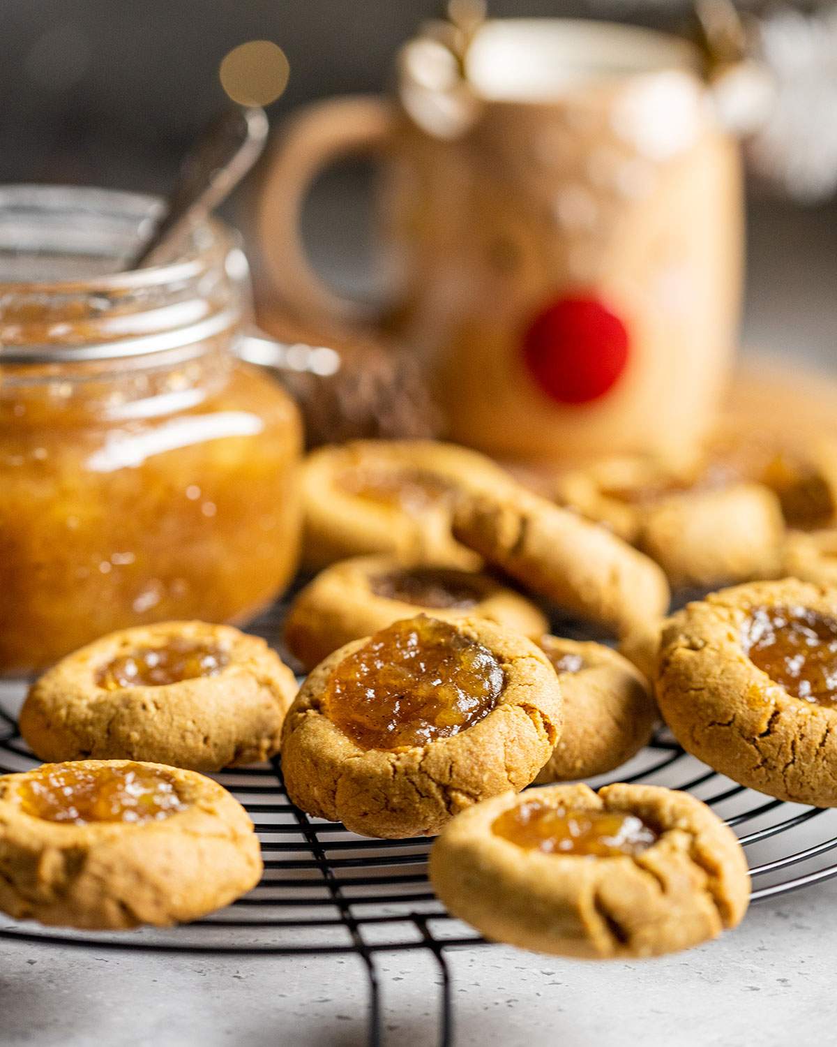 vegan thumbprint cookies with apple pie jam on a cooling rack