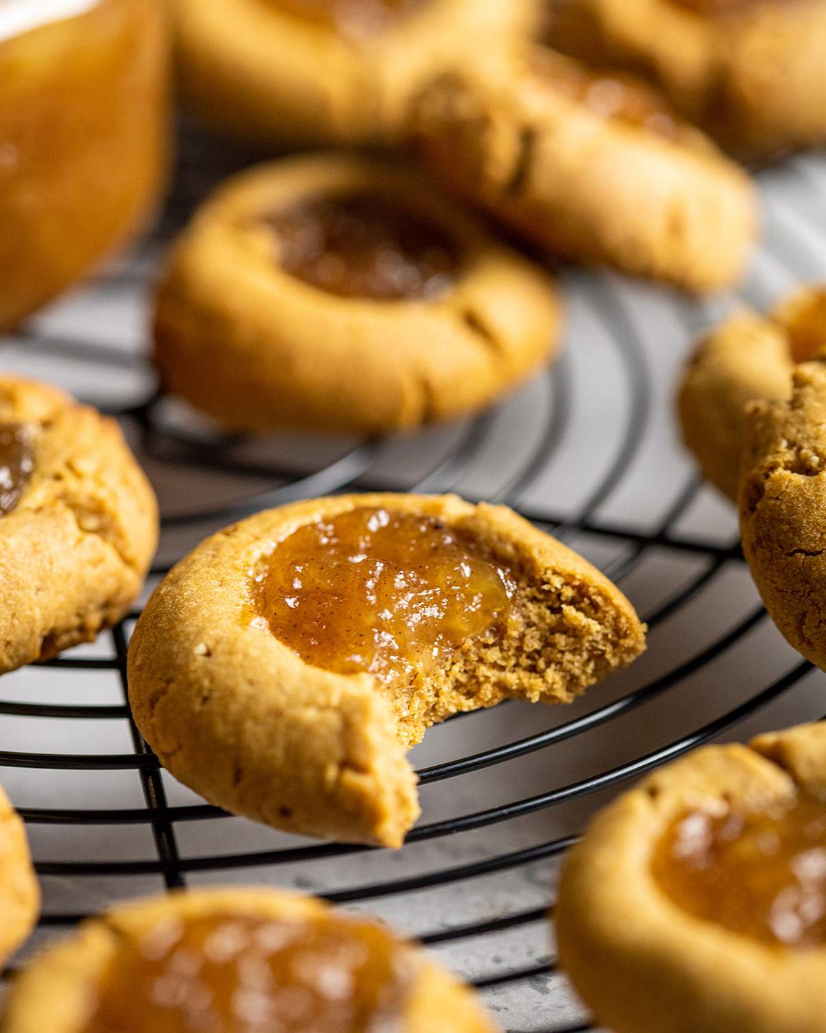 an apple pie cookies with a bite taken out of it on a cooling rack