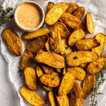 air fried fingerling potatoes on a white parchment with a dip on the side
