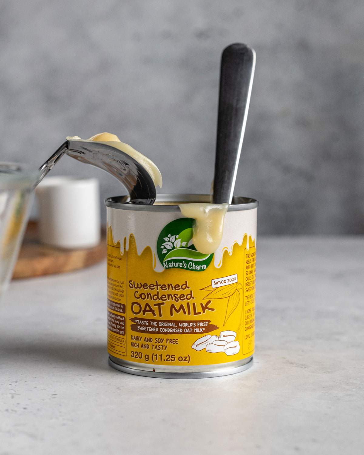 a can of sweetened condensed oat milk with a spoon coming out of it