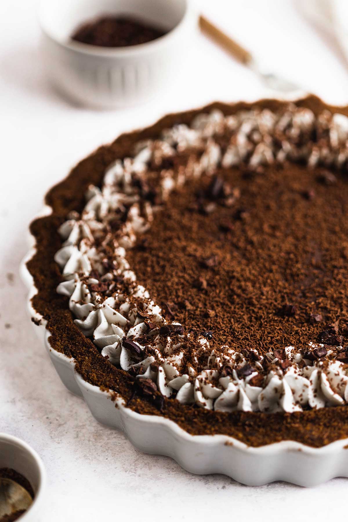 a round tart dish filled with vegan chocolate tart