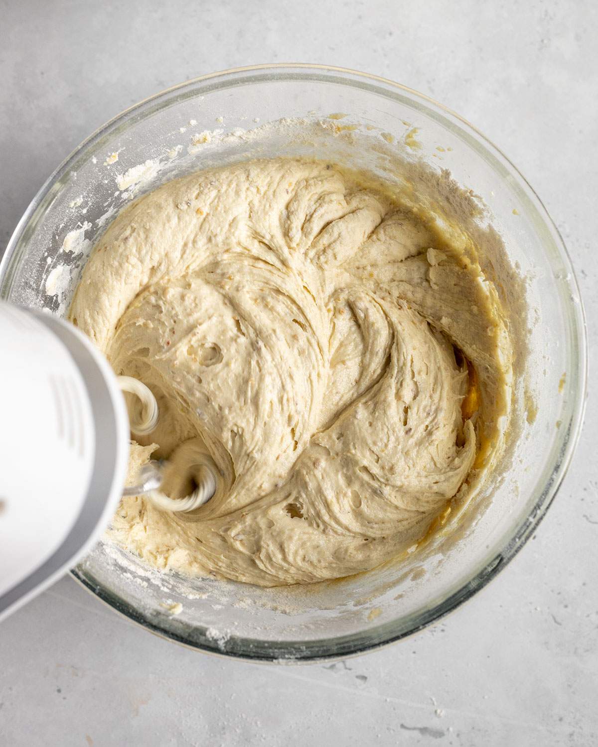 mixing condensed milk waffle batter in a glass bowl