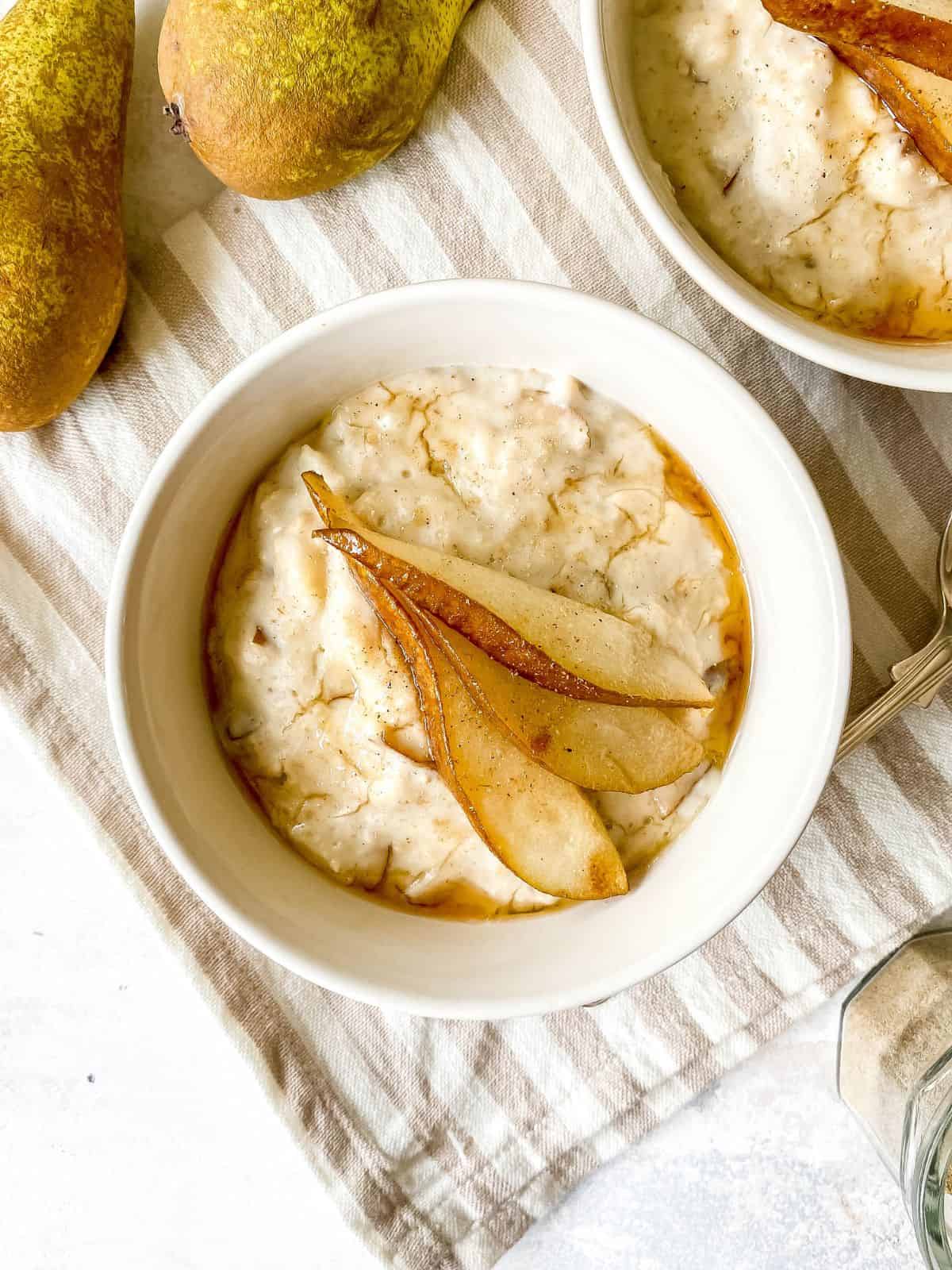 a bowl of vegan porridge topped with pear slices