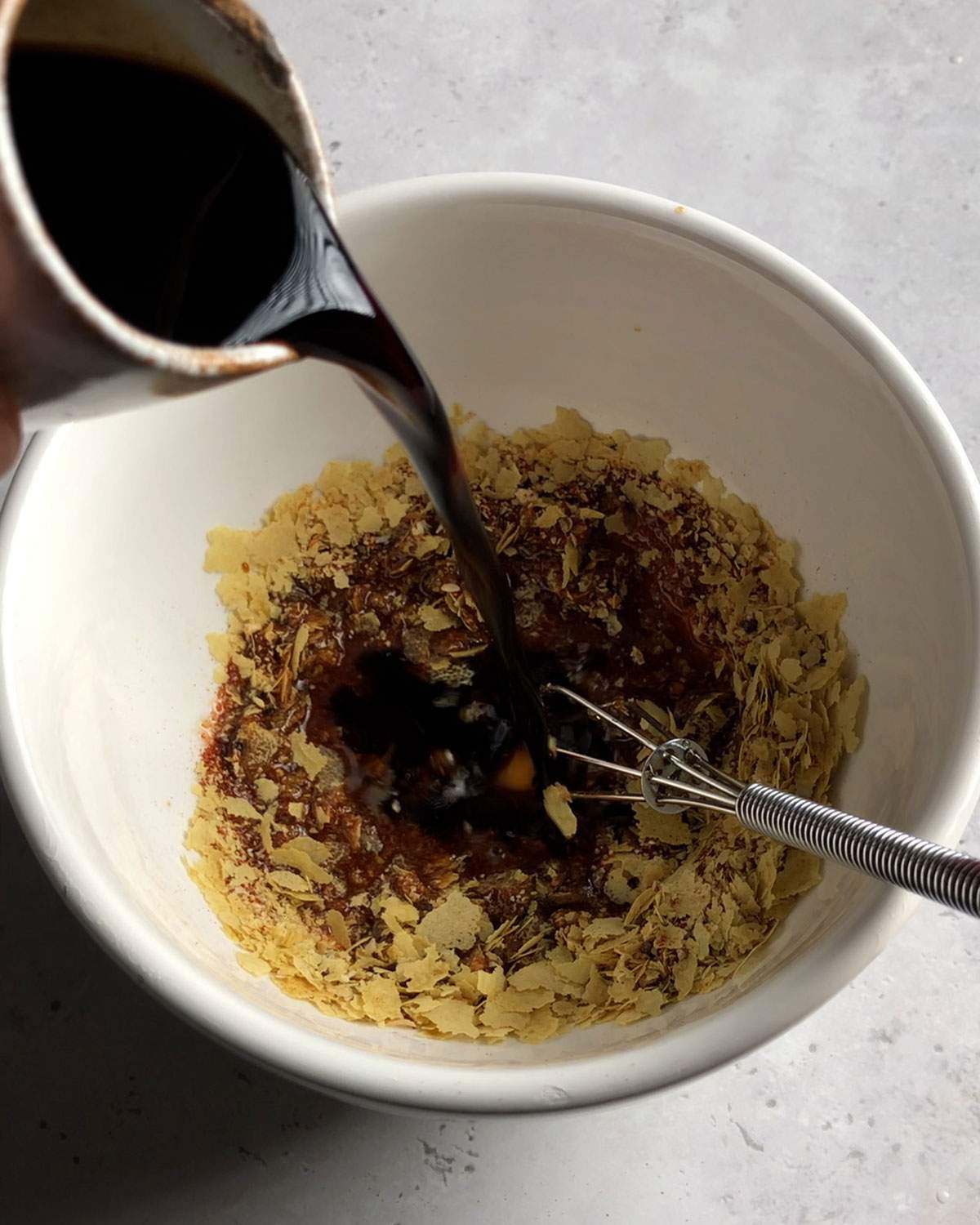 pouring soya sauce into a marinade