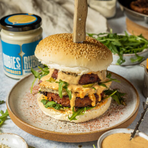 vegan big mac with vegan big mac sauce on a white plate