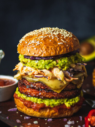 vegan burger with homemade vegan burger buns sitting on a black table