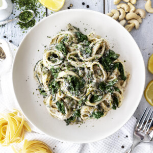 creamy vegan seafood pasta in a white bowl on a white table