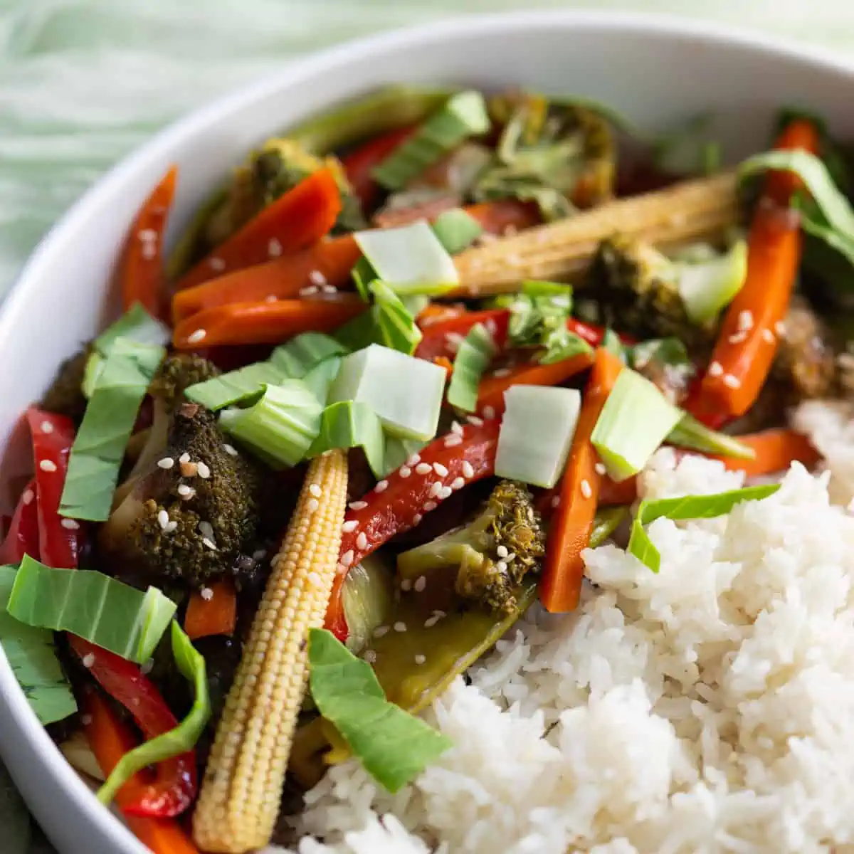 a white bowl filled with rice and vegan vegetable stir fry