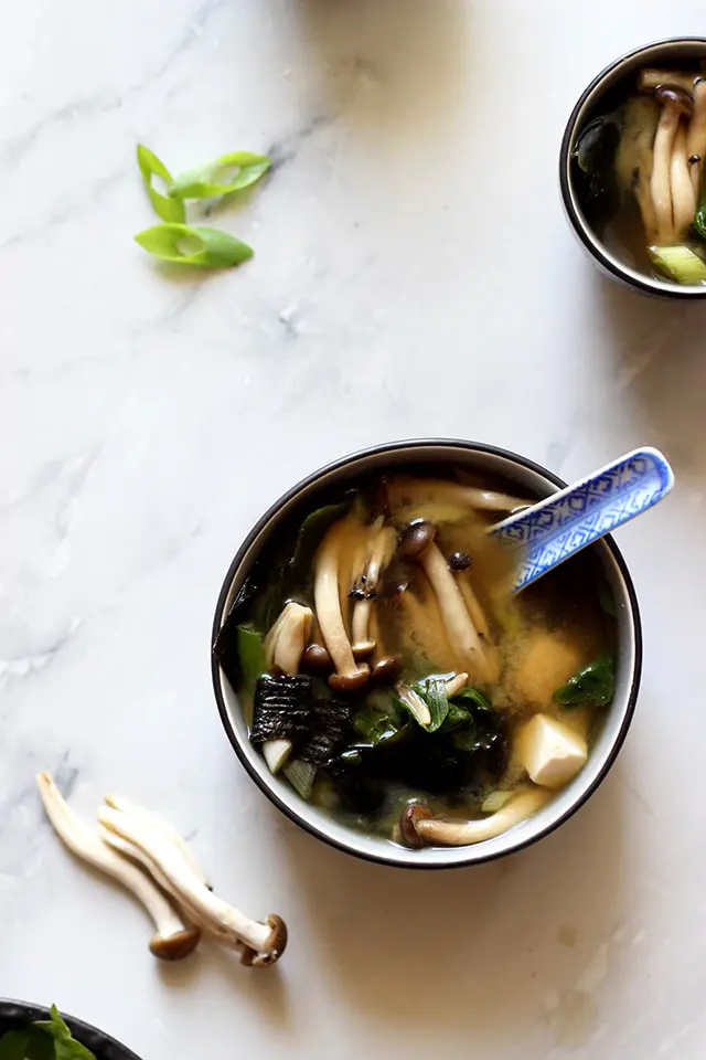 A bowl of delicious and healthy miso soup made with silken tofu, miso paste, and fresh green onions. The protein-rich tofu adds a smooth and creamy texture to the soup, while the miso paste and green onions provide a savory taste.