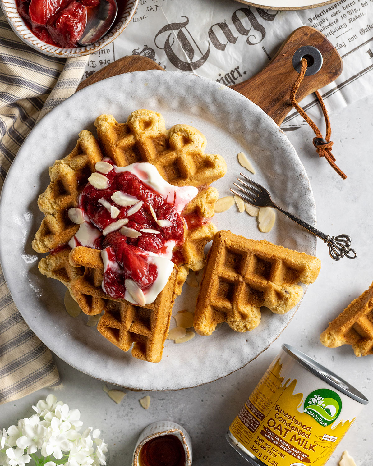condensed milk waffles on a plate with yogurt and strawberries on top