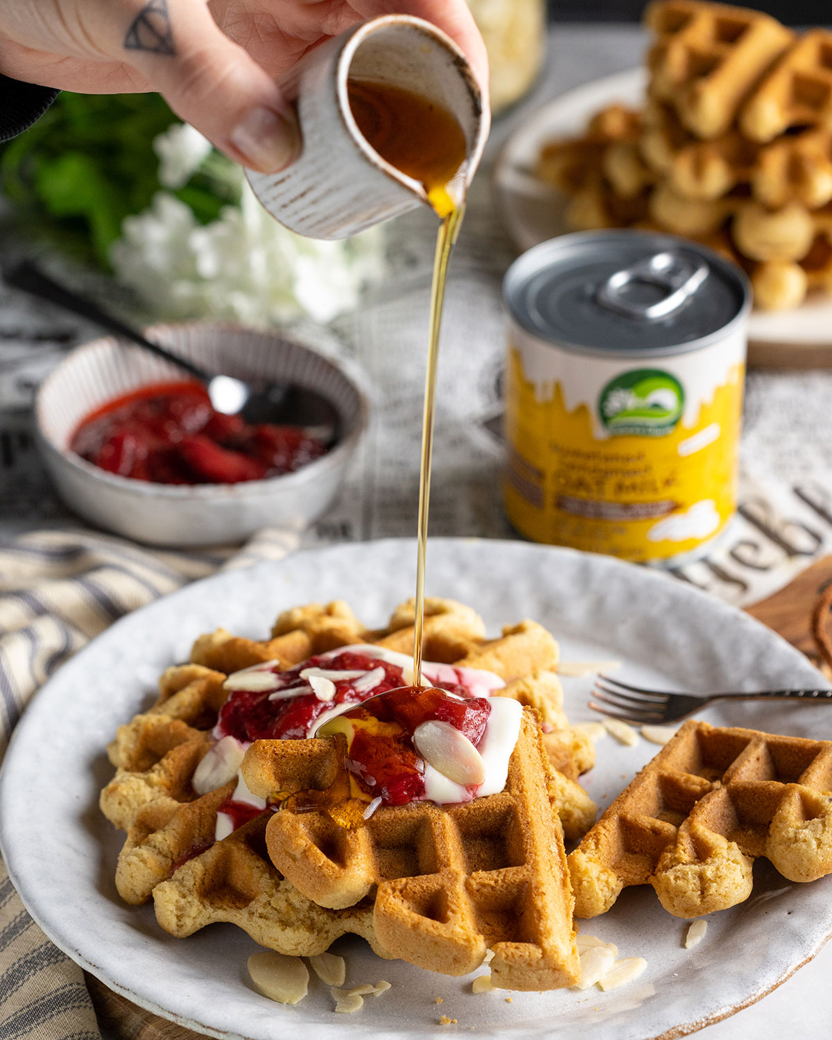 drizzling maple syrup onto vegan waffles