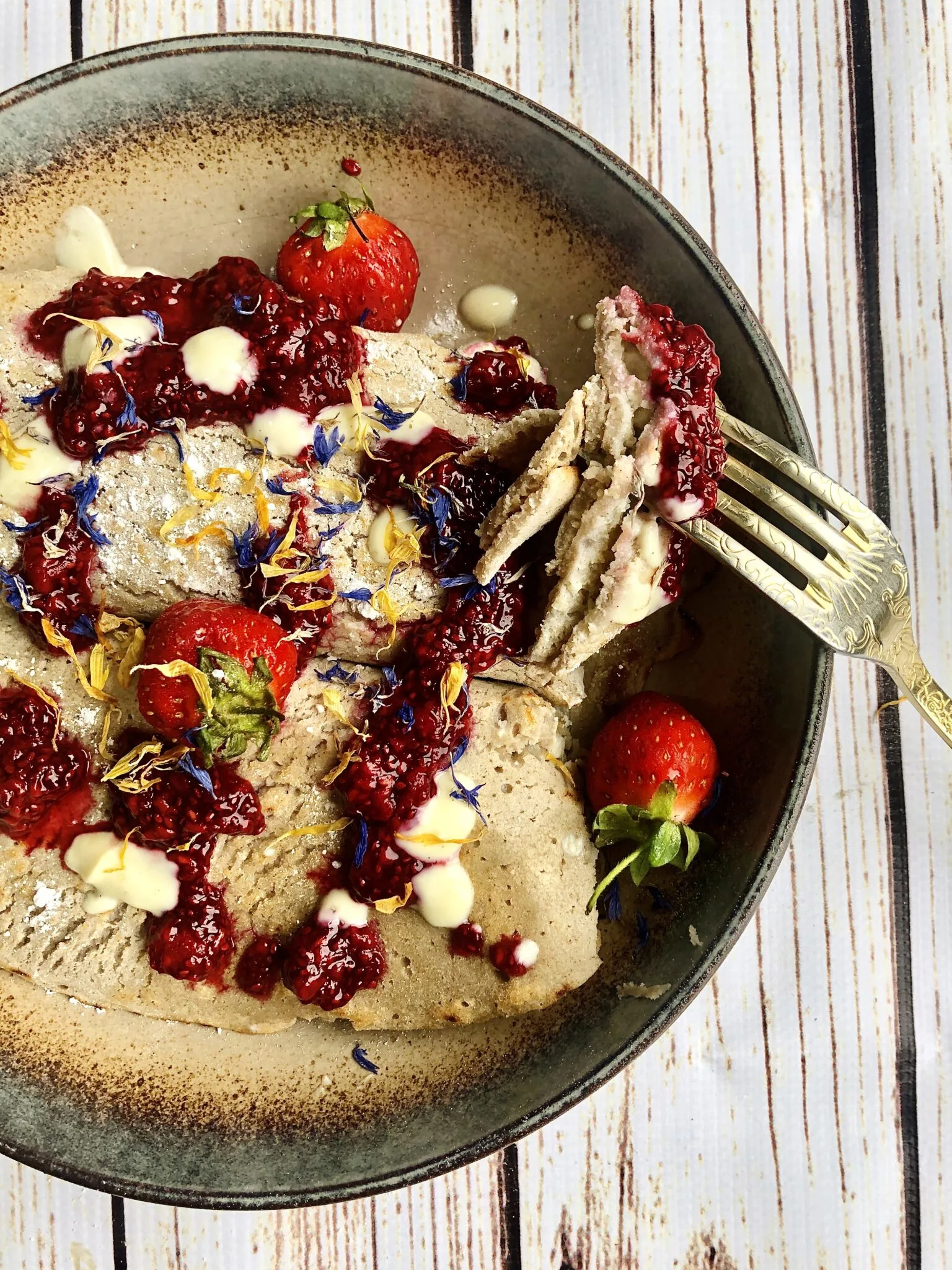 Vegan buckwheat crepes filled with a creamy and protein-rich silken tofu filling, topped with a sweet and tangy blueberry sauce and garnished with fresh mint leaves.