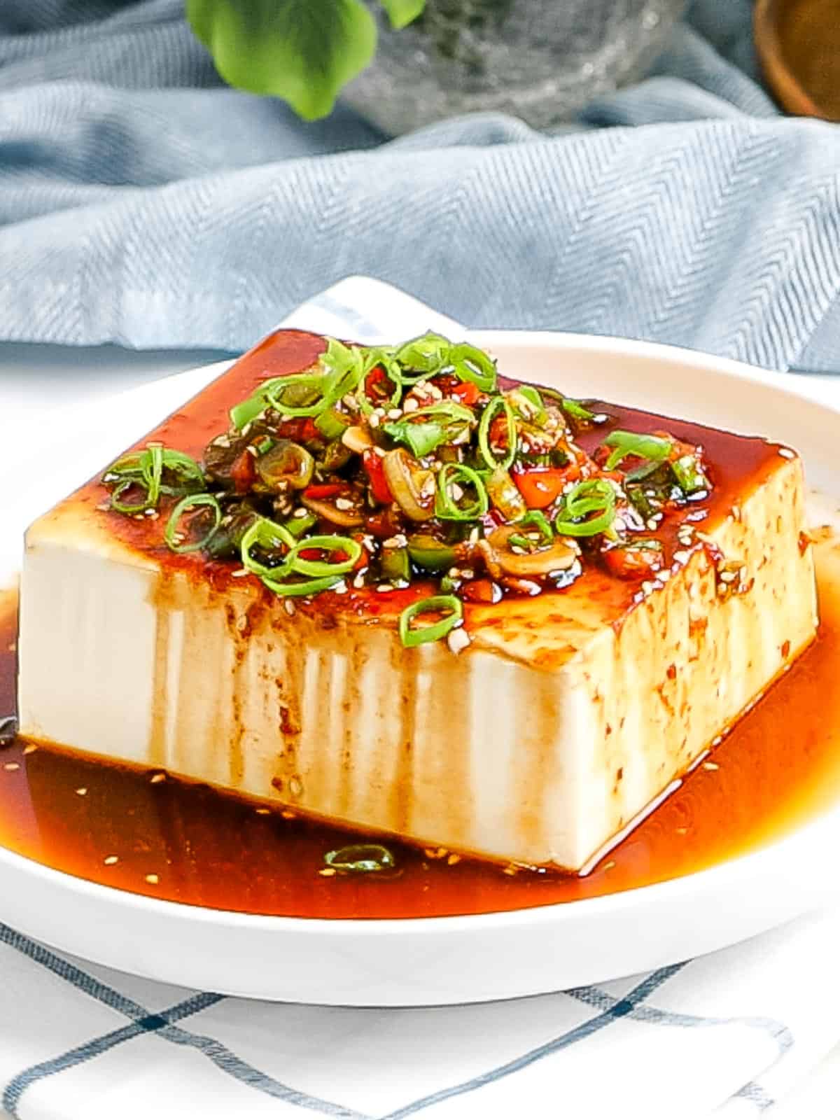 Silken tofu topped with a flavorful Korean soy sauce, sliced green onions and sesame seeds for a delicious and healthy snack or side dish.