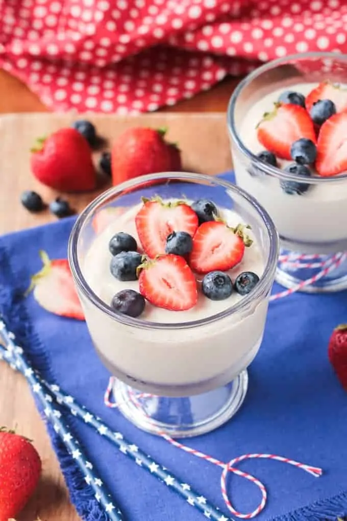 bowl of vegan vanilla pudding topped with fresh berries and mint leaves. The pudding is creamy and smooth, made with silken tofu and flavored with vanilla extract. The berries add a pop of color and sweetness to the dish.