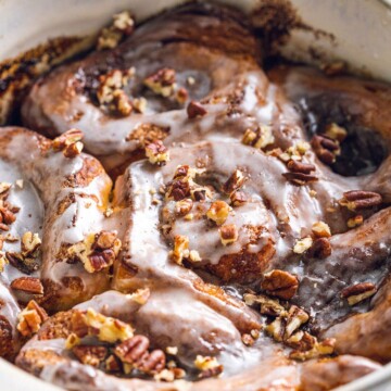 Close up of TikTok Cinnamon Rolls in an oven dish with crunchy nuts on top