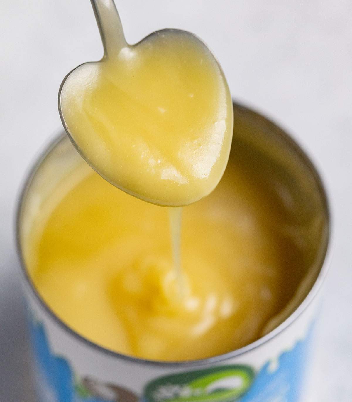 a spoon lifting condensed milk out of a can_003