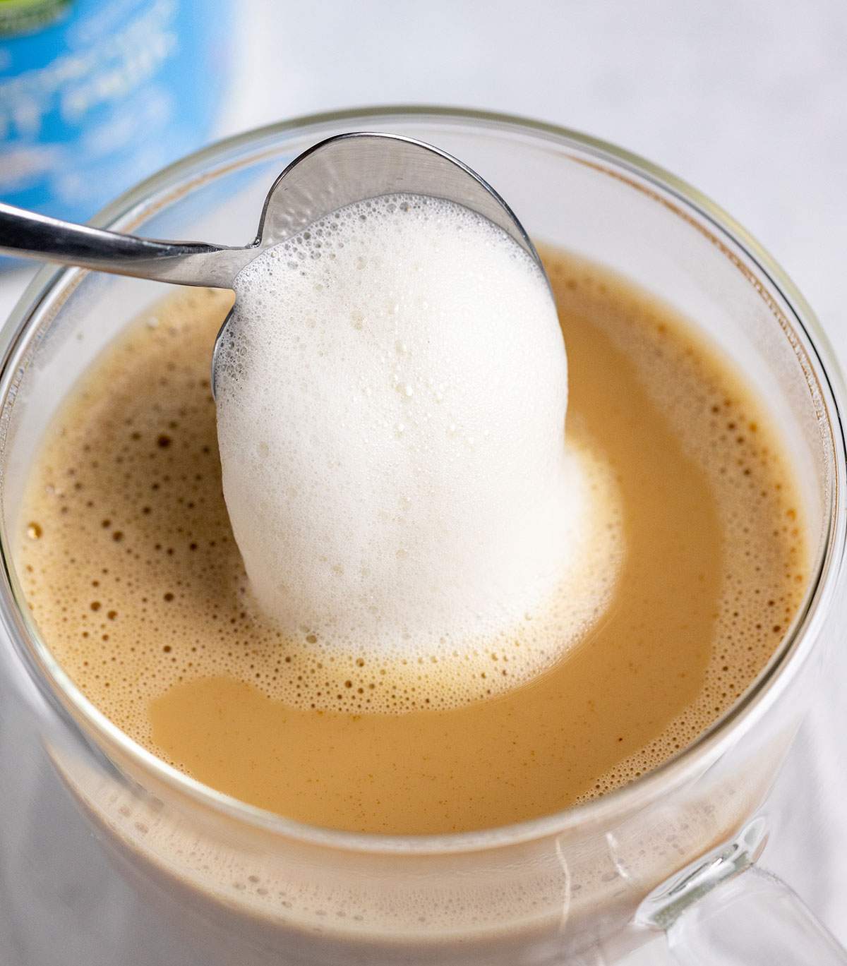 a spoon topping a spanish latte with frothed milk_002