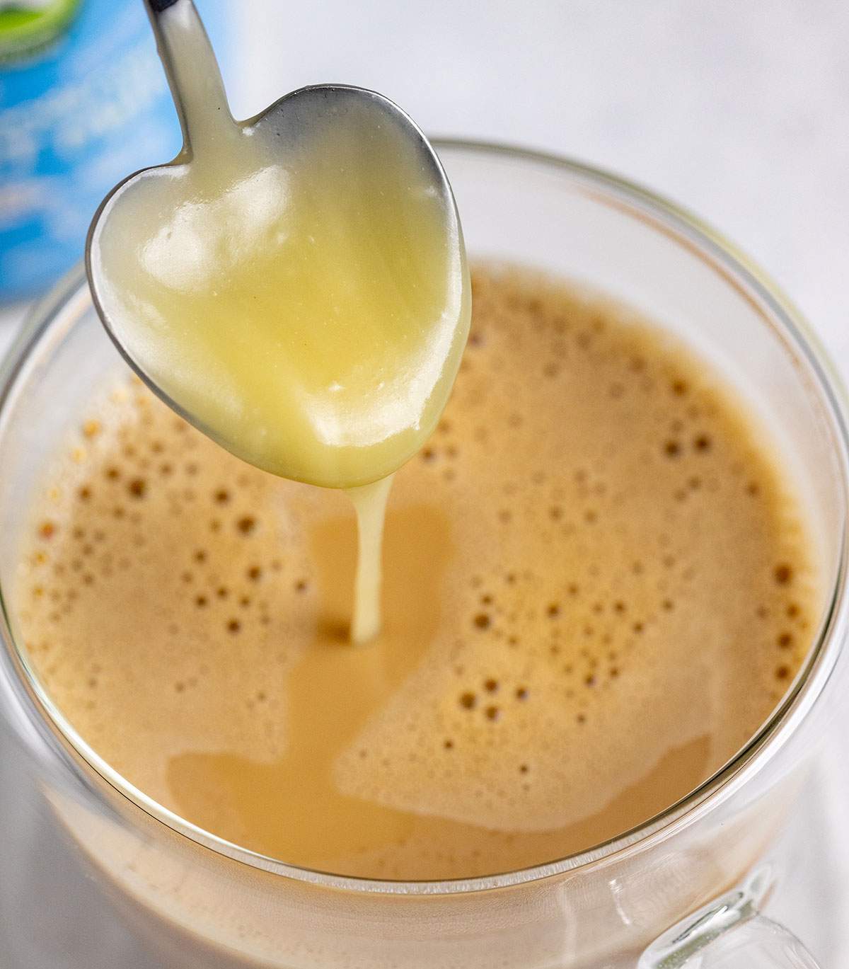 adding condensed milk to a coffee for spanish latte