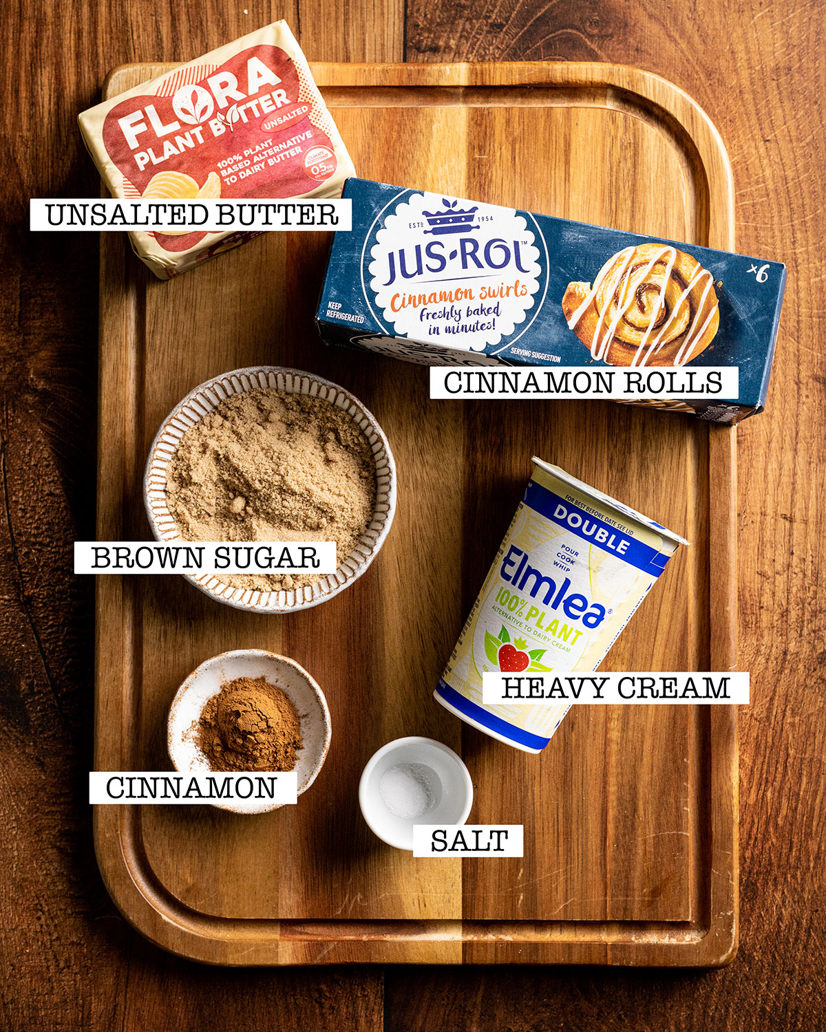 ingredients for tiktok cinnamon rolls on a wooden board with labels