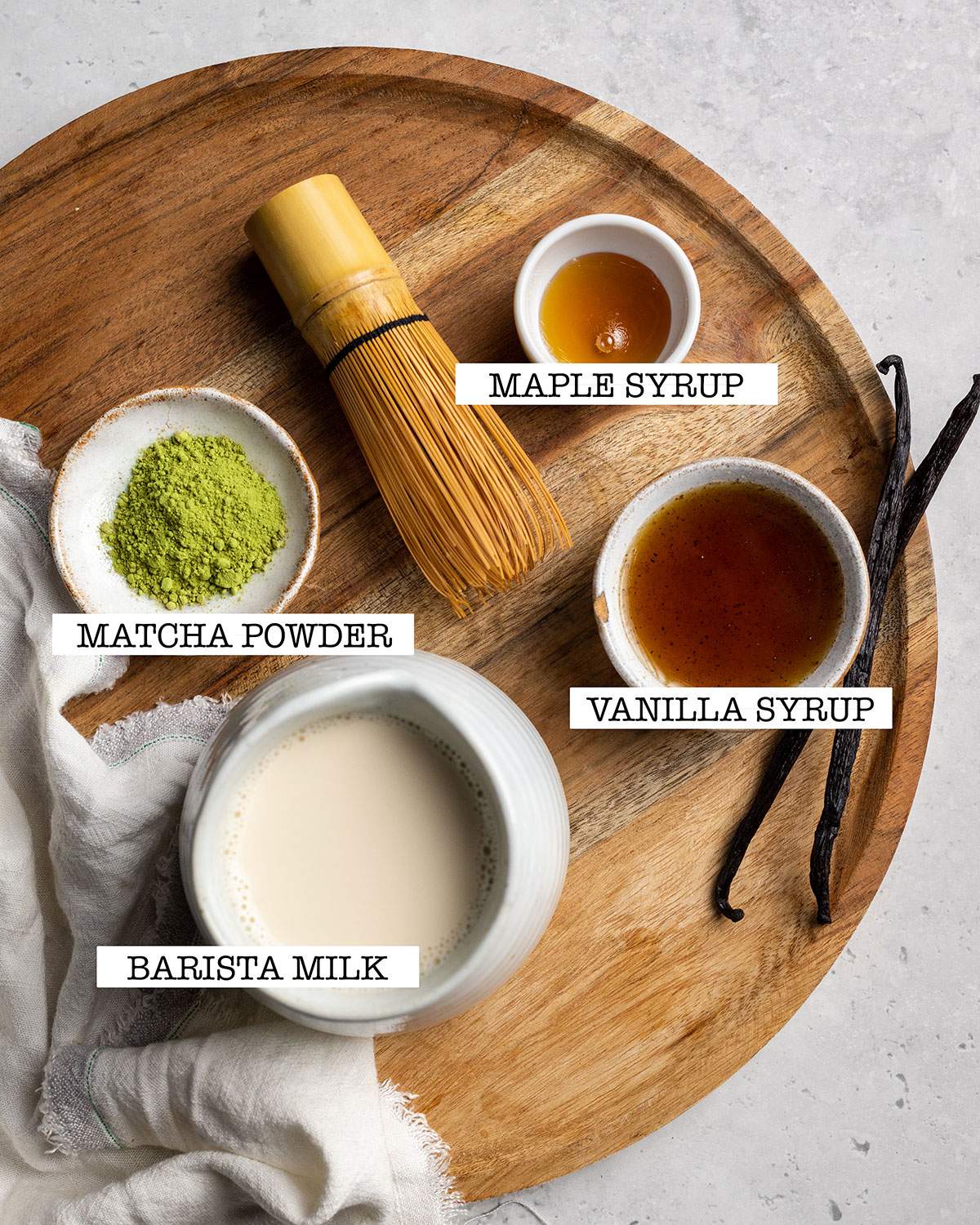 ingredients-for-vanilla-matcha-latte on a wooden tray with labels