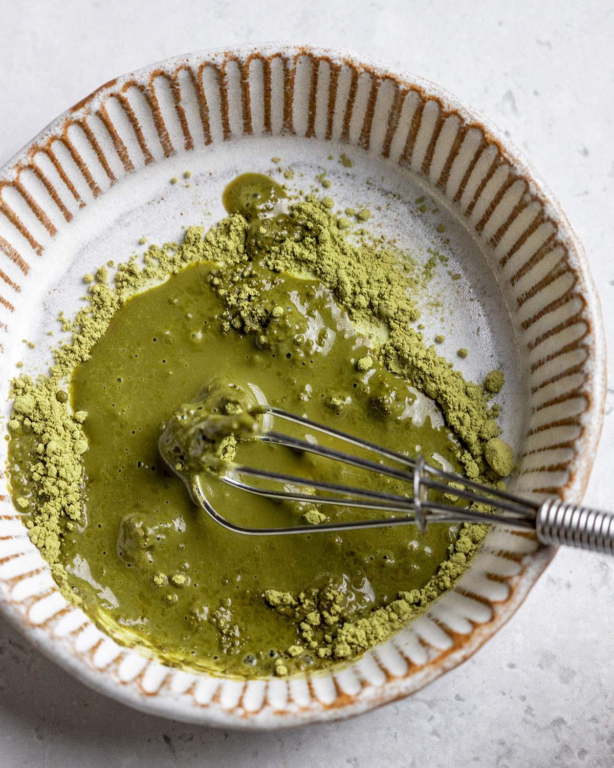 mixing matcha paste in a small bowl