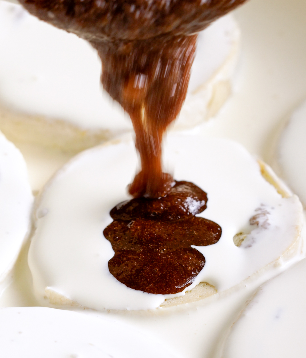 pouring cinnamon sugar glaze onto cinnamon rolls