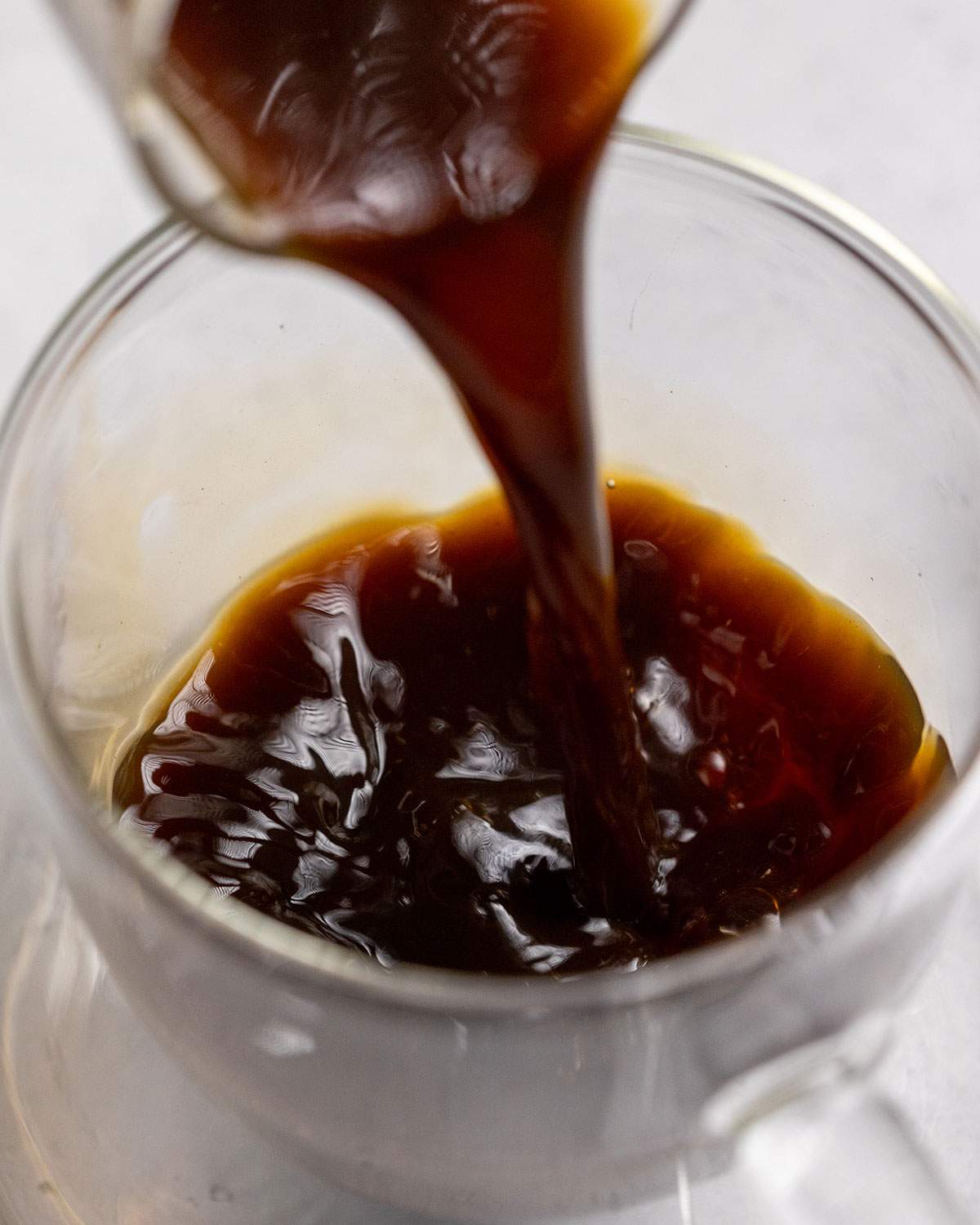 pouring espresso into a cup