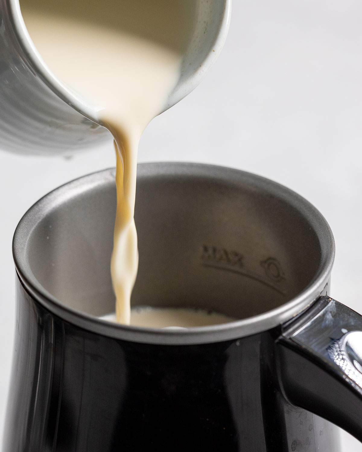 pouring milk into a milk frother