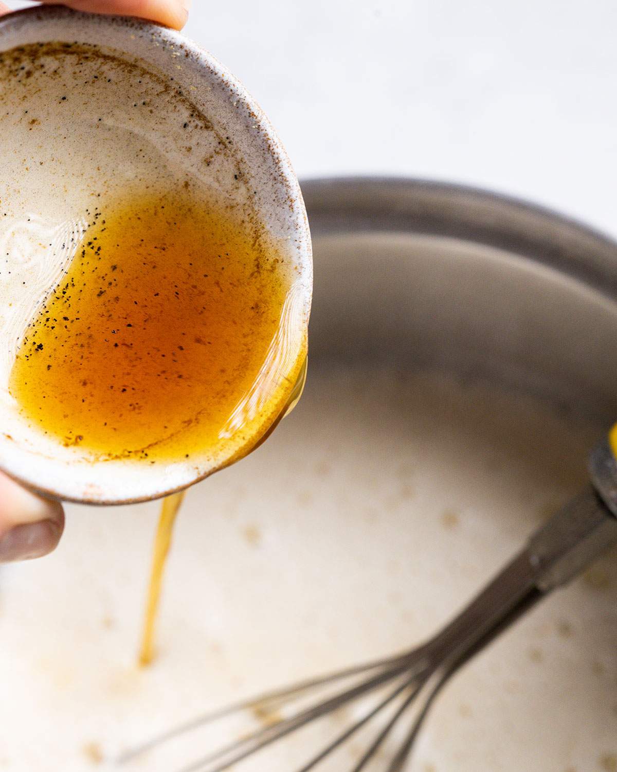 pouring vanilla syrup into hot milk