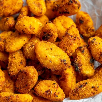 Crispy air fryer gnocchi shown up close in a bowl with a white parchment underneath.